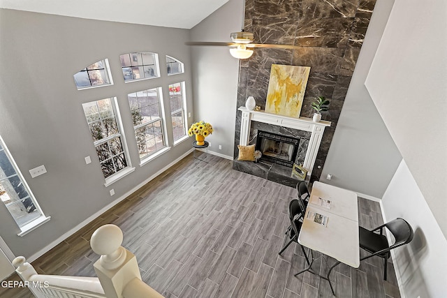 living room featuring a high end fireplace and ceiling fan