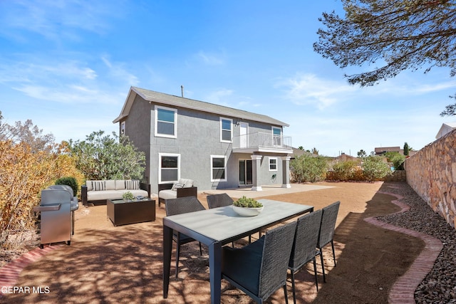 back of house featuring an outdoor living space, a patio area, and a balcony