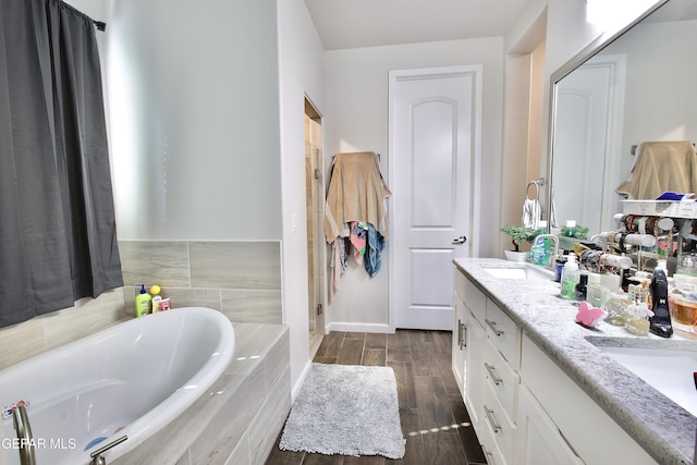 bathroom with vanity and tiled bath