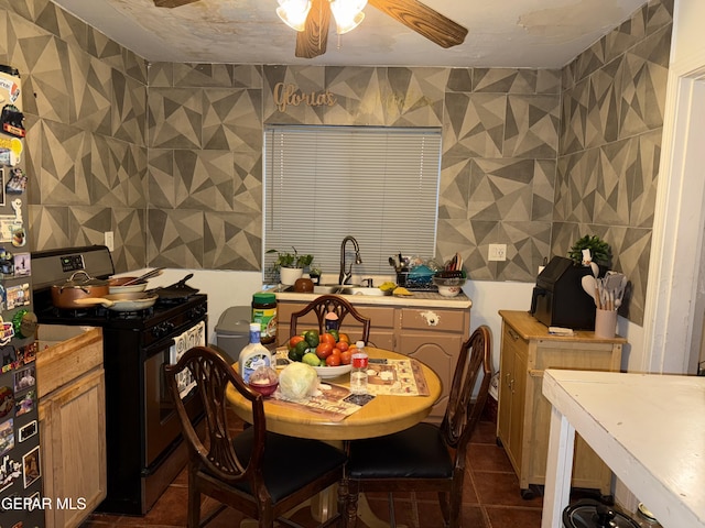 tiled dining area featuring ceiling fan and sink