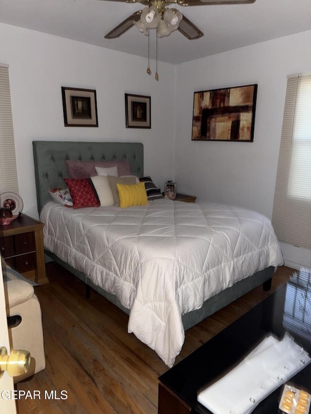 bedroom with dark hardwood / wood-style floors and ceiling fan