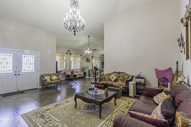 living room with vaulted ceiling, dark hardwood / wood-style floors, and ceiling fan with notable chandelier