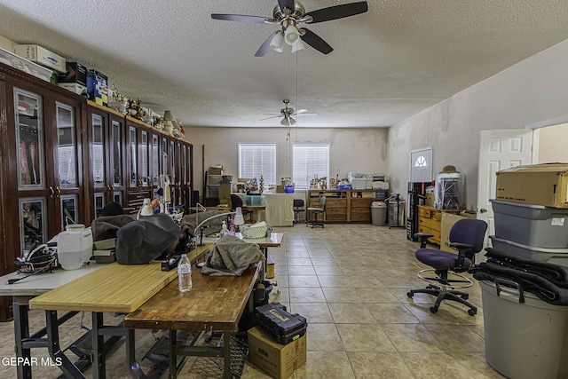 tiled office space with a textured ceiling and ceiling fan