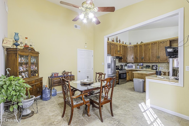 dining room featuring ceiling fan and high vaulted ceiling