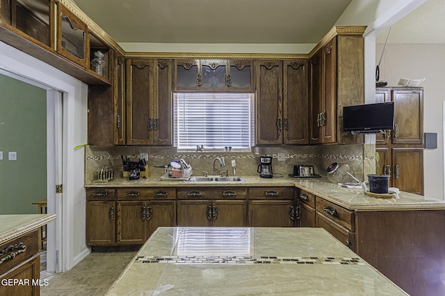 kitchen featuring pendant lighting, tasteful backsplash, dark brown cabinetry, and sink