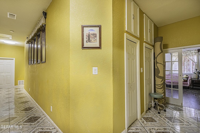 corridor with french doors and light tile patterned flooring