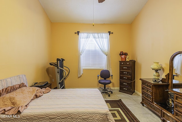 tiled bedroom with a textured ceiling and ceiling fan