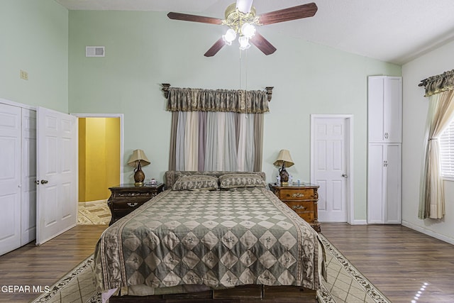 bedroom with ceiling fan, dark hardwood / wood-style floors, and high vaulted ceiling