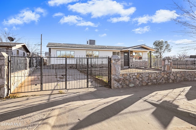 ranch-style house with a fenced front yard, a gate, and stucco siding