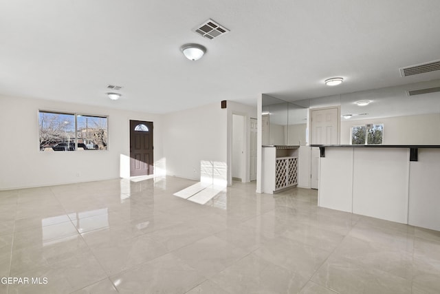 unfurnished living room with visible vents