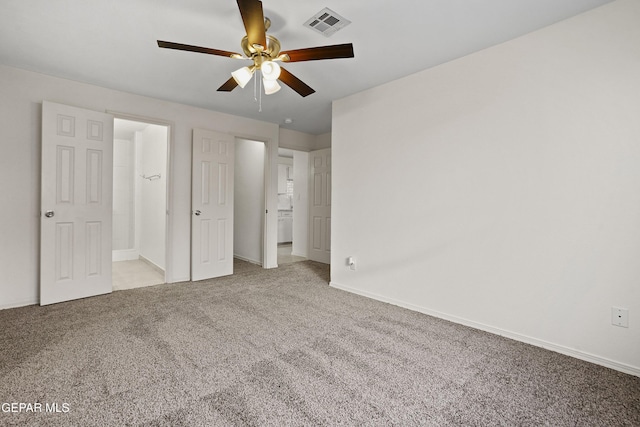 unfurnished bedroom with connected bathroom, ceiling fan, and light colored carpet