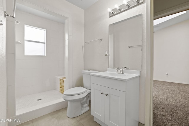 bathroom featuring toilet, a tile shower, vanity, and tile patterned floors