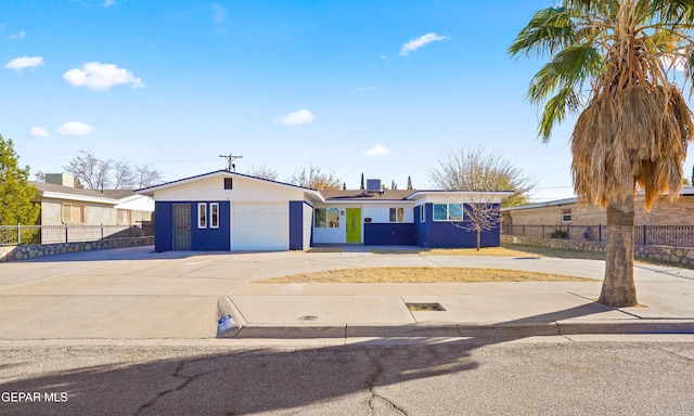 ranch-style house featuring central AC unit, a garage, and solar panels