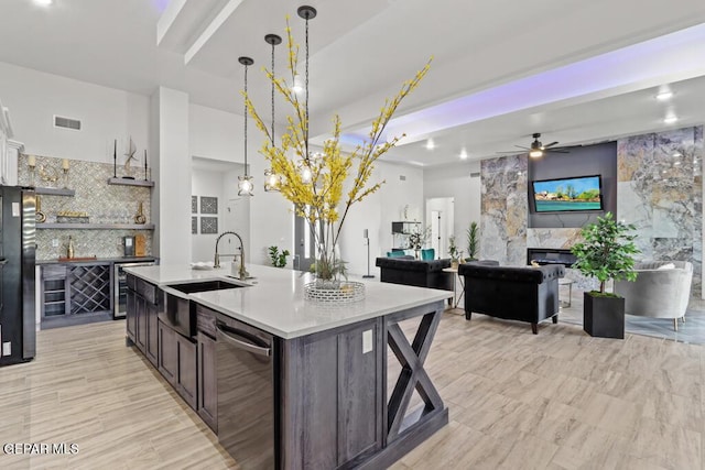 kitchen featuring sink, an island with sink, pendant lighting, and appliances with stainless steel finishes