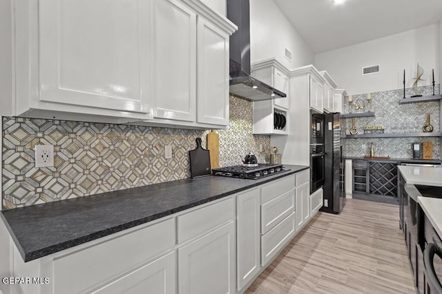 kitchen with white cabinetry and wall chimney exhaust hood
