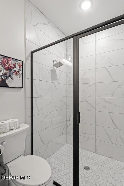 bathroom with toilet and a shower with door