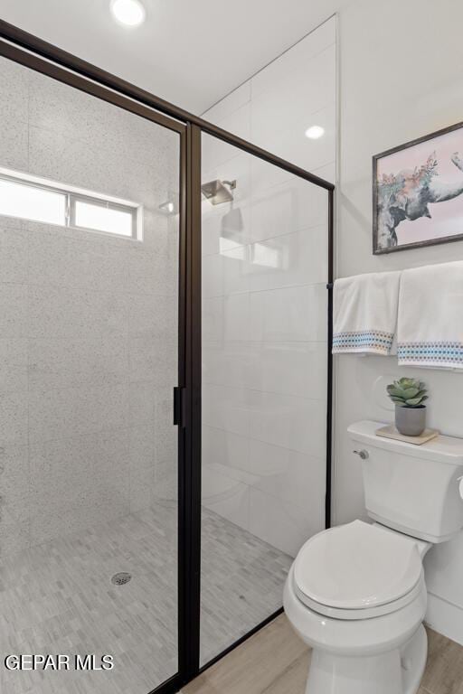bathroom featuring hardwood / wood-style floors, toilet, and walk in shower