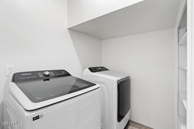 laundry area featuring light hardwood / wood-style flooring and washing machine and dryer
