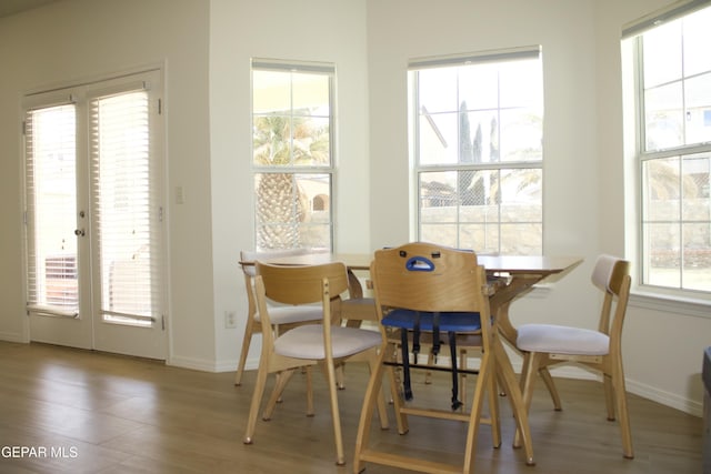 dining space with wood-type flooring and french doors