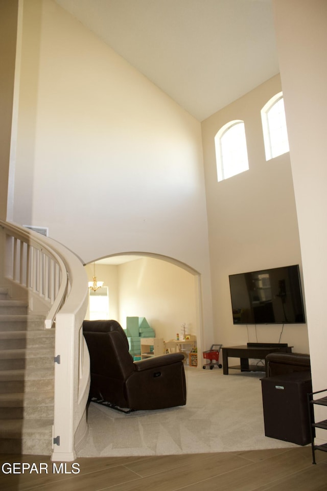 living room featuring a notable chandelier, high vaulted ceiling, and hardwood / wood-style floors