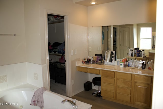 bathroom with wood-type flooring, vanity, and a bathtub