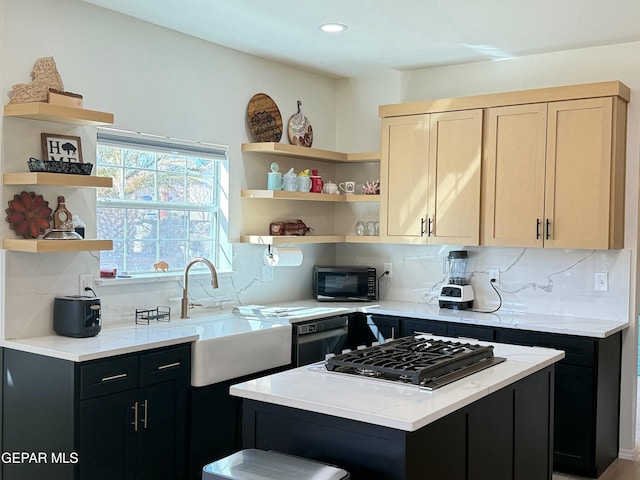 kitchen featuring light brown cabinetry, tasteful backsplash, sink, a center island, and black appliances