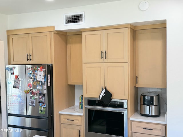 kitchen with appliances with stainless steel finishes and light brown cabinets