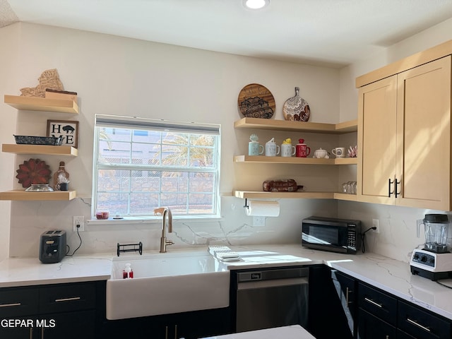 kitchen with light stone counters, sink, decorative backsplash, and black appliances