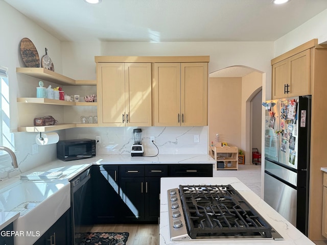 kitchen featuring decorative backsplash, light hardwood / wood-style floors, black appliances, light stone countertops, and light brown cabinets