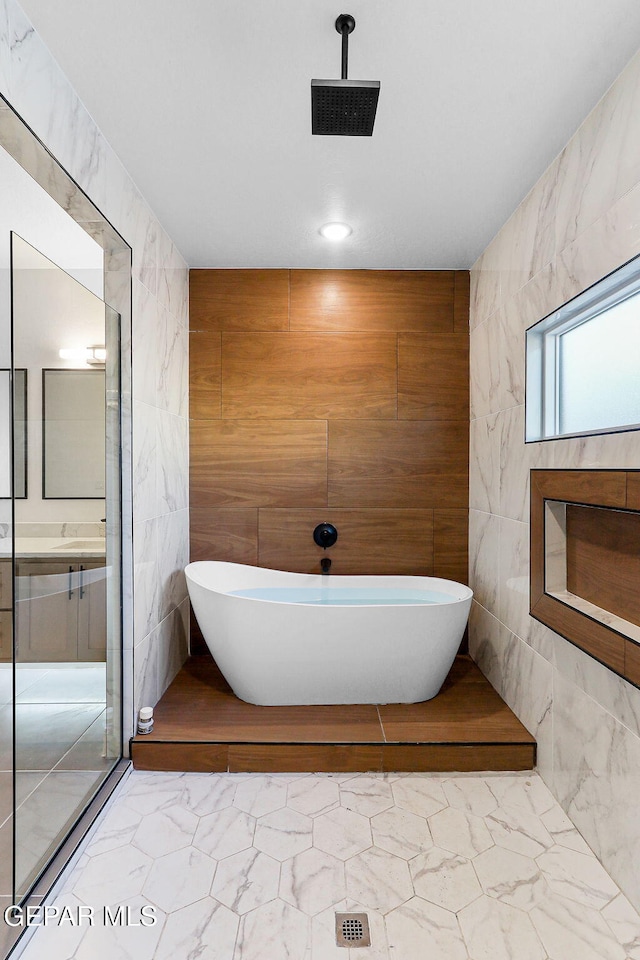 bathroom with a tub and tile walls