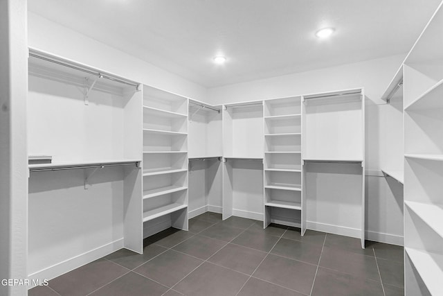 walk in closet with dark tile patterned floors