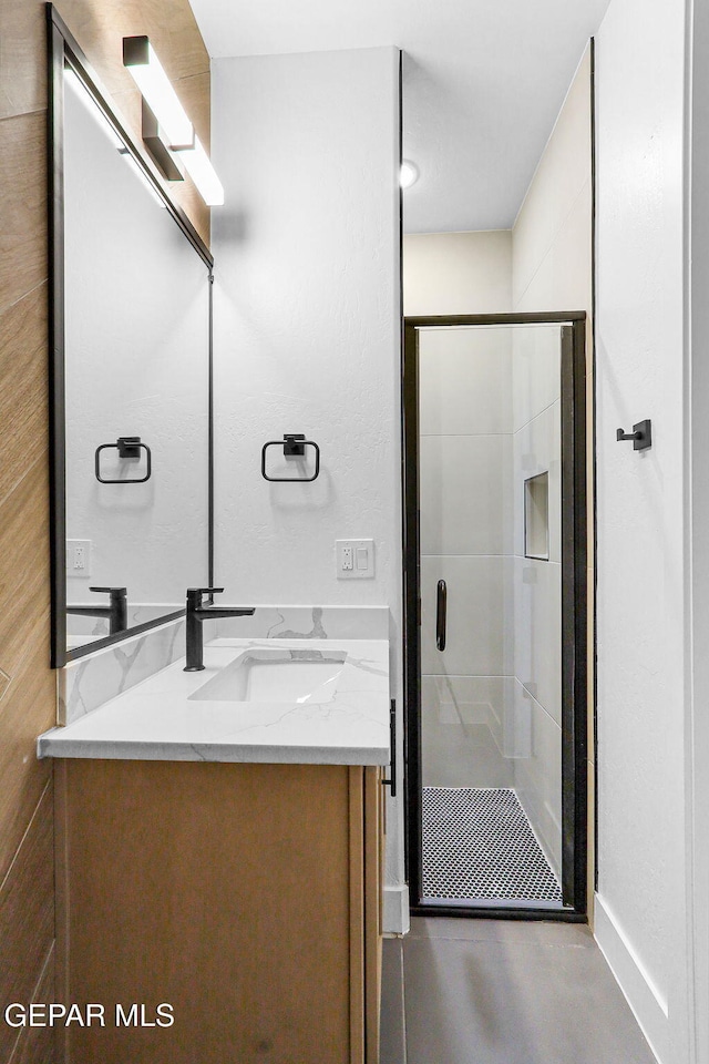 bathroom with vanity and a shower with shower door