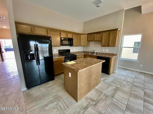 kitchen with black appliances, sink, plenty of natural light, and a kitchen island