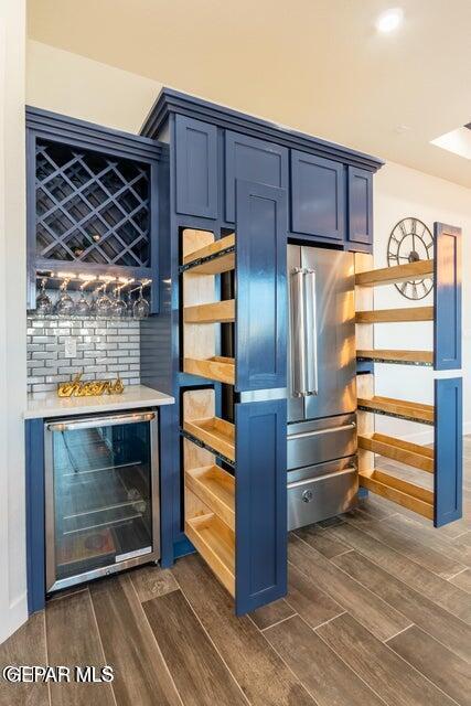 bar featuring blue cabinetry and beverage cooler