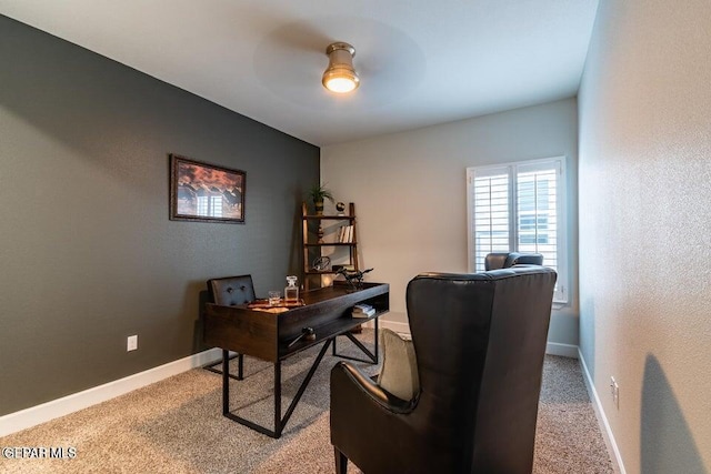 carpeted office space featuring ceiling fan