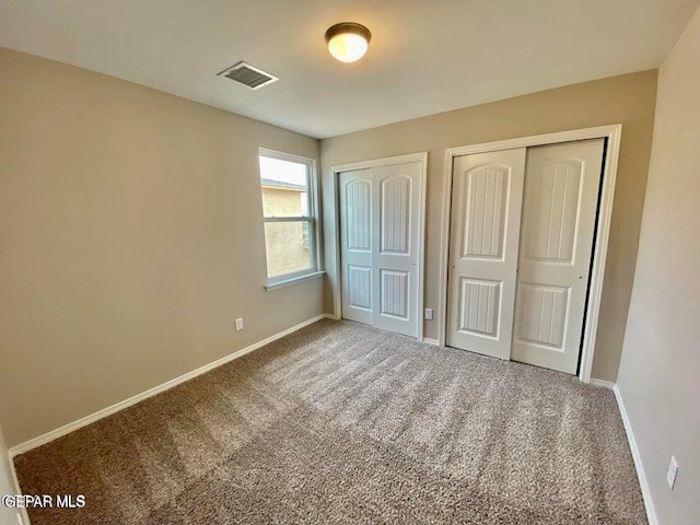 unfurnished bedroom with two closets and carpet