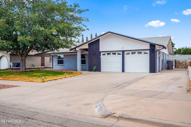 ranch-style house featuring a garage and a front lawn