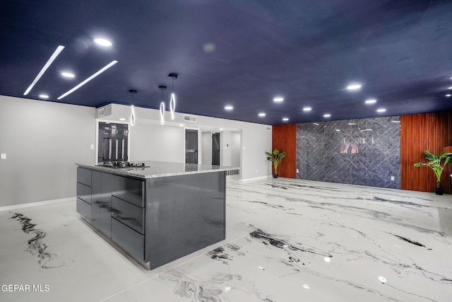 kitchen featuring a large island, decorative light fixtures, stone counters, and black gas cooktop