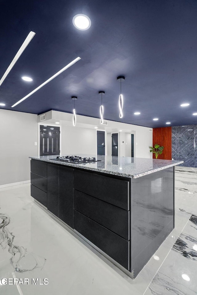 kitchen featuring refrigerator, decorative light fixtures, stainless steel gas cooktop, and a spacious island