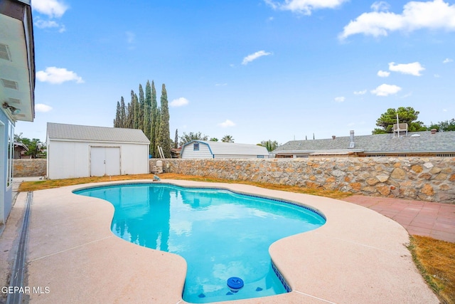 view of pool featuring a patio and an outbuilding