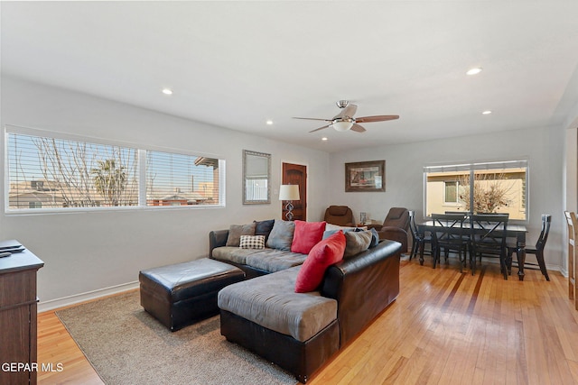 living room featuring ceiling fan, plenty of natural light, and light hardwood / wood-style flooring