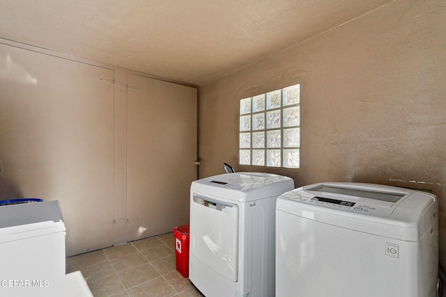 laundry area with washing machine and dryer and light tile patterned floors