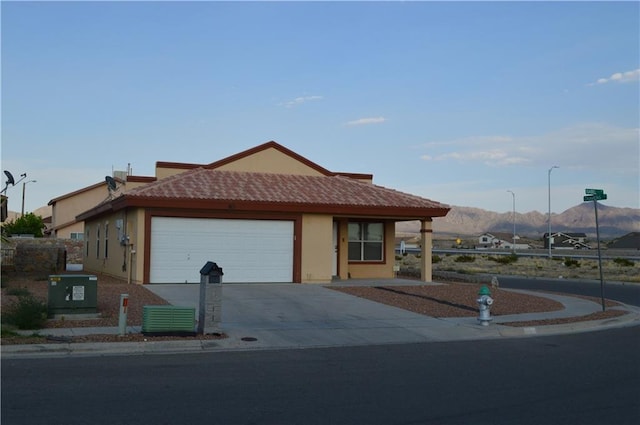 view of front of house with central AC, a garage, and a mountain view