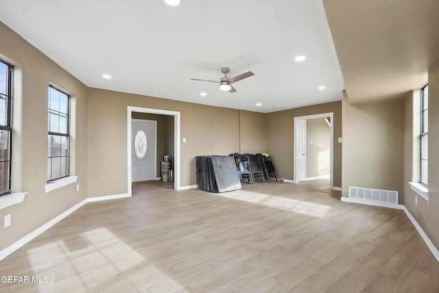 unfurnished living room featuring ceiling fan, plenty of natural light, and light hardwood / wood-style flooring