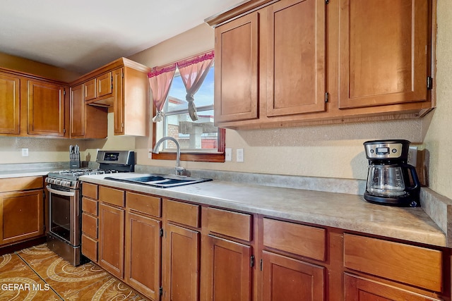 kitchen featuring sink, stainless steel range with gas cooktop, and light tile patterned floors