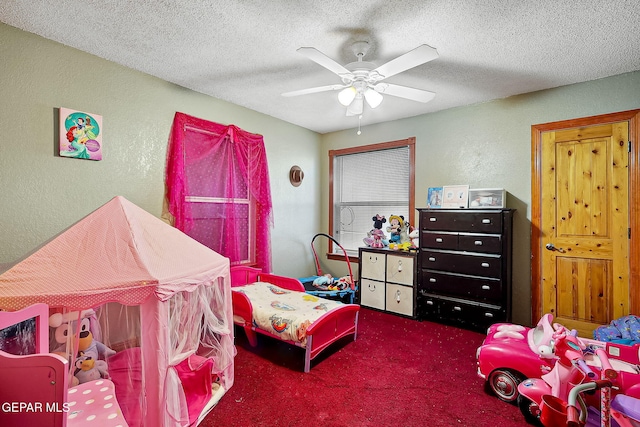 bedroom featuring a textured ceiling, dark colored carpet, and ceiling fan