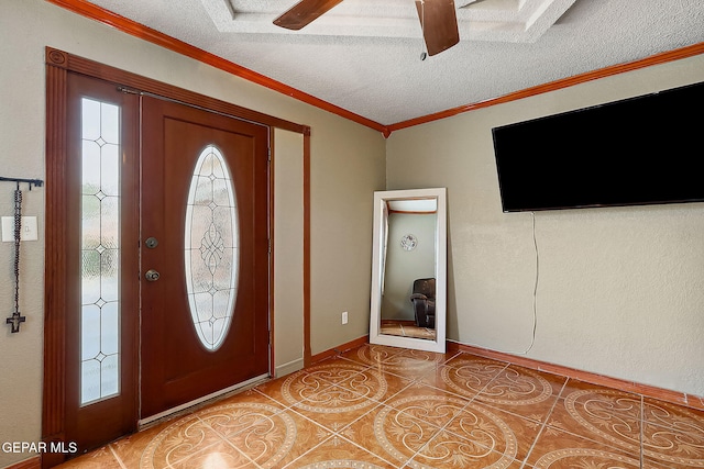 tiled foyer entrance featuring a textured ceiling, ceiling fan, plenty of natural light, and ornamental molding