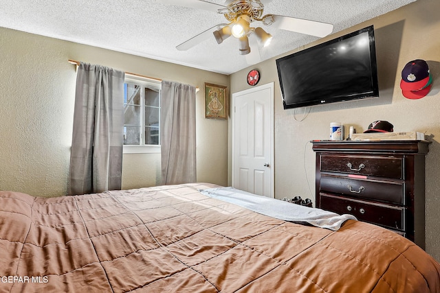 bedroom with ceiling fan and a textured ceiling