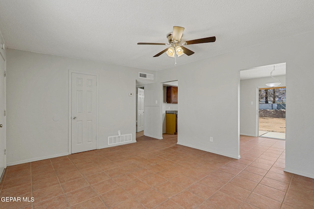 tiled spare room with ceiling fan and a textured ceiling