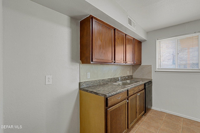 kitchen with sink, light tile patterned flooring, a textured ceiling, and black dishwasher